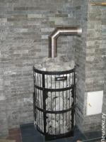 Банная печь Harvia Legend со стороны парной. Топка выведена в стену. Подключена к керамическому дымоходу