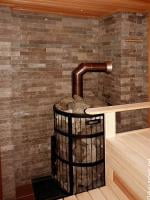 Банная печь Harvia Legend со стороны парной. Топка выведена в стену. Подключена к керамическому дымоходу